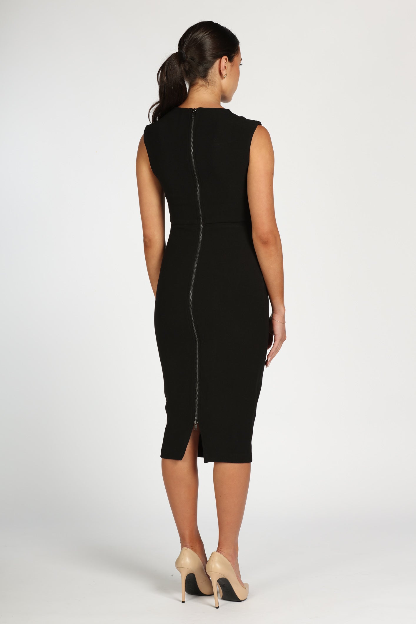 Woman wearing a black dress with a zipper back on a white background
